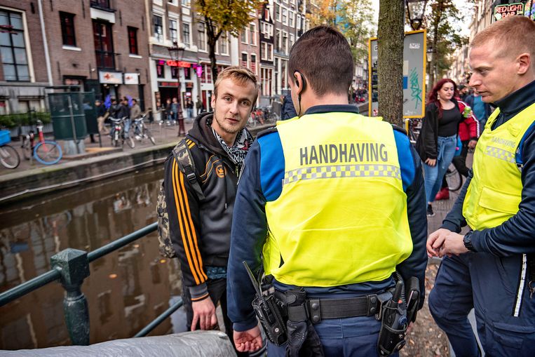 Boa's houden op de Wallen een Oost-Europese man aan wegens openbare dronkenschap.
 Beeld Guus Dubbelman / de Volkskrant