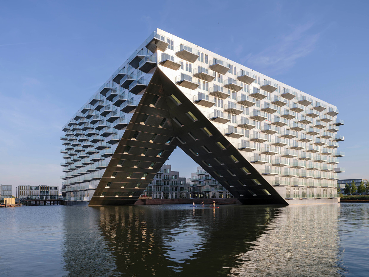 Het Sluishuis op IJburg, dat uit 441 energieneutrale appartementen bestaat, heeft een opengesneden hoek en trappen die leiden naar het dak. Architecten: Bjarke Ingels Group en Barcode. Beeld Ossip van Duivenbode