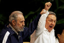 Fidel Castro (links) houdt de hand van zijn broer Raúl omhoog tijdens een congres van de Communistische Partij in 2011.