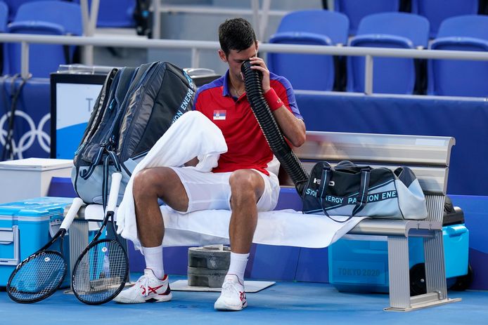 Novak Djokovic blaast zichzelf wat frisse lucht toe tijdens zijn partij met Alejandro Davidovich Fokina.