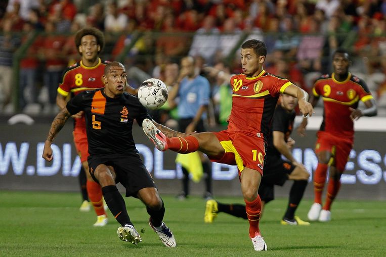Eden Hazard in duel met Nigel de Jong tijdens een vriendschappelijke match tegen Nederland in 2012, de dageraad van de Gouden Duivels.  Beeld BELGA