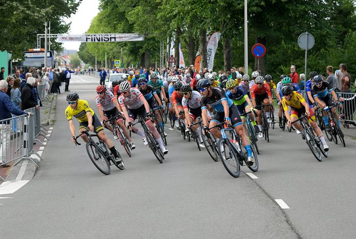 Het peloton neemt na de herstart van de Slag van Ambacht de eerste bocht, waar een half uur eerder enkele renners lelijk ten val kwamen.