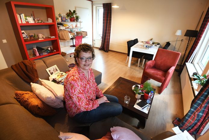 Agna van Rees in haar tijdelijke appartementje, met links de rode VVD-boekenkast.