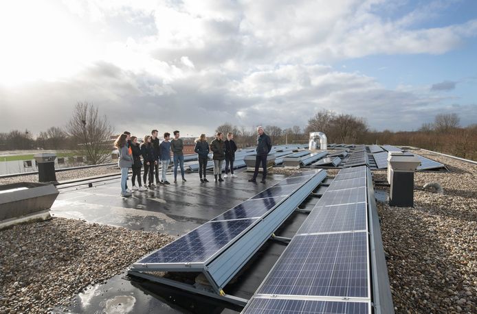 Natuurkundeleraar Michiel van Duin vertelt op het dak van het Pallas Athene College aan een groepje leerlingen uit 4 vwo hoe zonnepanelen werken.
