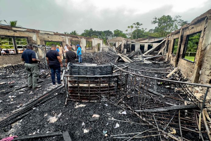 Onderzoekers inspecteren de school die in brand werd gestoken. Het gedeeltelijk houten gebouw is volledig uitgebrand. (22/05/23)
