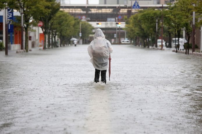 Een inwoner van de provincie Saga loopt door het water, nadat zware regen de straten blank hebben gezet.