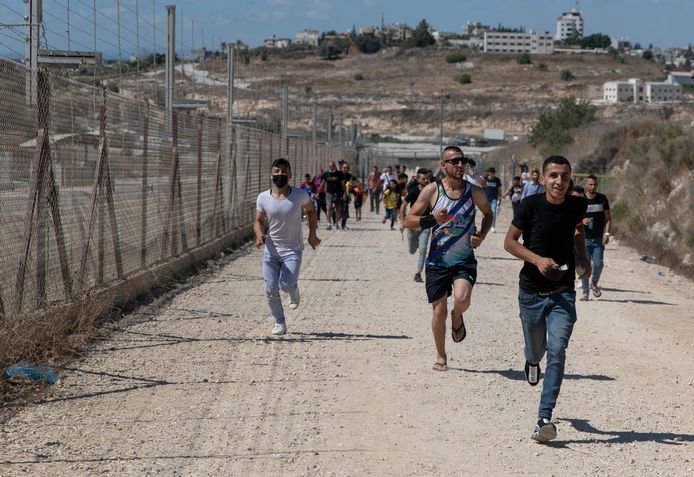 Palestijnen op de noordwestelijke Jordaanoever profiteren van een gat in een Israëlisch hek voor een dagje op het strand.