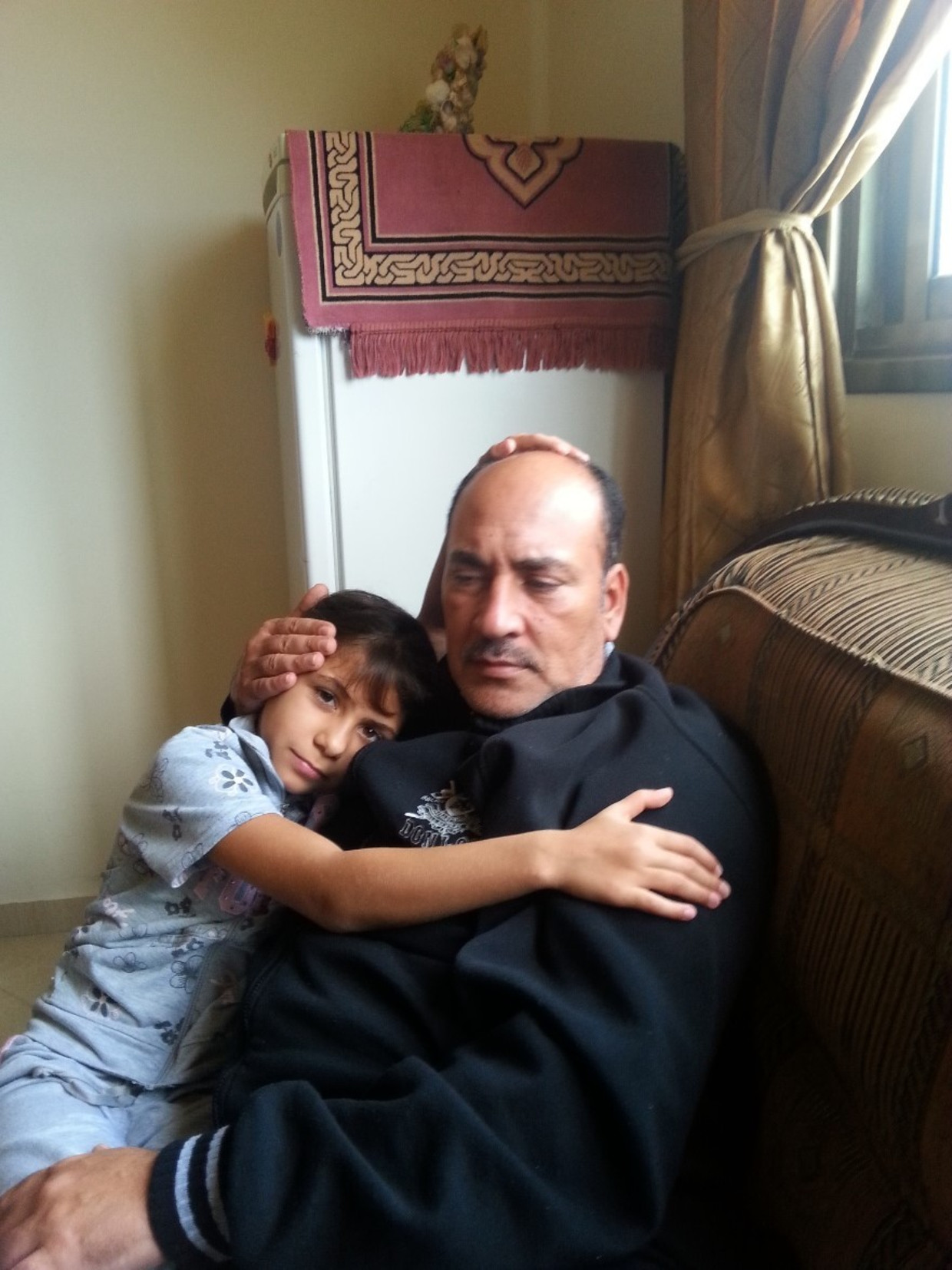 Mostafa Kahlout met zijn dochter Hala. Beeld CARE/Alison Baskerville