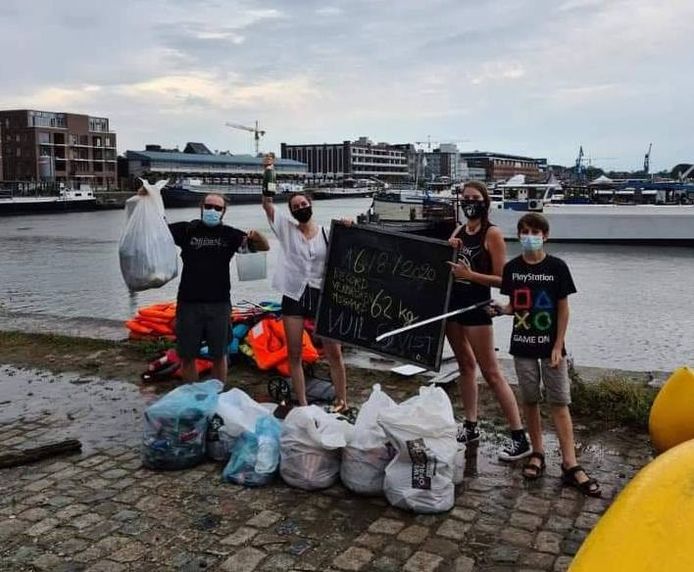 Leden van Jeugdhuis Asgaard tonen trots hun recordhoeveelheid afval die ze uit het water haalden.