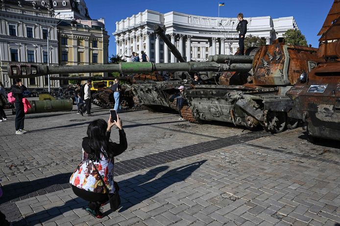 Kinderen poseren voor foto's op vernielde Russische tanks die tentoongesteld staan in Kiev. Beeld van 6 oktober.