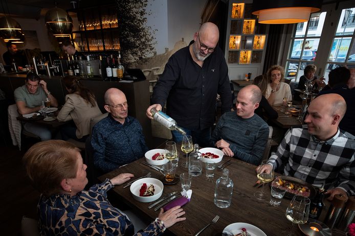 Bert-Jan de Win schenkt een frisse witte wijn in restaurant de Zwaan.