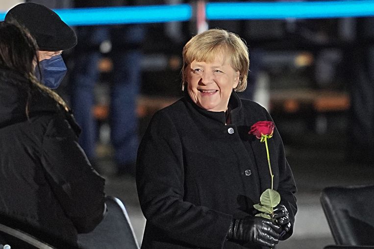 Angela Merkel krijgt een roos tijdens haar afscheidsceremonie, begin december.  Beeld Michael Kappeler/dpa