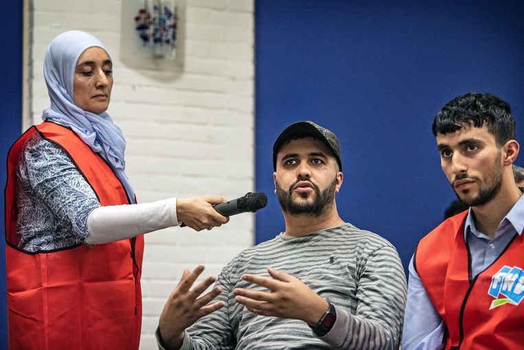 Inwoners, veelal van Marokkaanse komaf, van de wijk Hillesluis luisteren aandachtig naar woorvoerder FNV op een voorlichtingsavond over overheidsprogramma Systeem Risico Indicatie ( SyRi ). Het publiek kon vragen stellen en deed dat ook. Beeld Guus Dubbelman / De Volkskrant