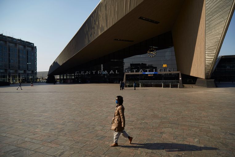 Behalve een vrouw met mondkapje is het rustig op het anders zo drukke Rotterdamse stationsplein.  Beeld Getty Images