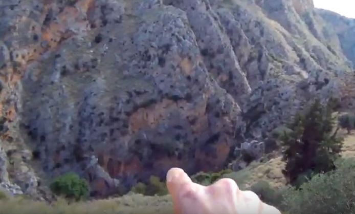 Een Amerikaanse toerist wijst naar de 200 meter diepe Rokka-kloof in het noordwesten van Kreta.