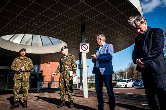 Dokter Marcel Visser (rechts) en onder meer twee leden van de Nederlandse strijdkrachten staan de pers te woord aan de ingang van een ziekenhuis in Tilburg (Noord-Brabant).