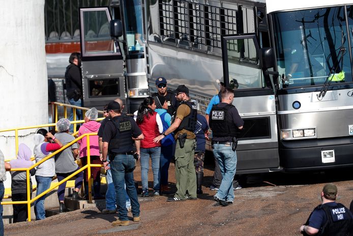 Arbeidsters worden op de bus naar aan detentiecentrum gezet na een inval van de Amerikaanse autoriteiten bij Koch Foods, een bedrijf in Morton, Mississippi.