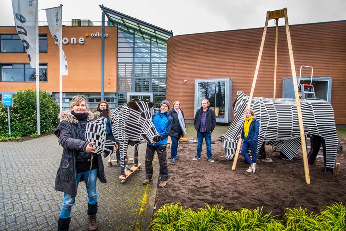 Ruim 200 leerlingen hebben twee koeien, een varken en een kip gemaakt, zaterdag zetten kunstenares Meg Mercx (vooraan) en de docenten de stapel in elkaar. De veestapel is een blijvertje op het plein voor het Zone.college aan de Hengelosestraat.