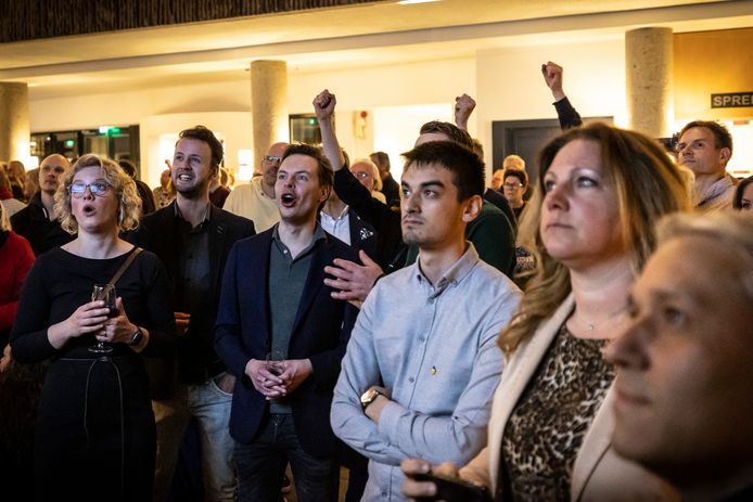 Voorzichtige vreugde bij Rutger Bouwman (voorgrond, derde van links) van Solidair Oldenzaal bij de uitslag bij één van de stembureaus. De algehele uitslag is dan nog niet bekend. Bouwman mag dan blij zijn, niet iedereen kijkt even vrolijk.