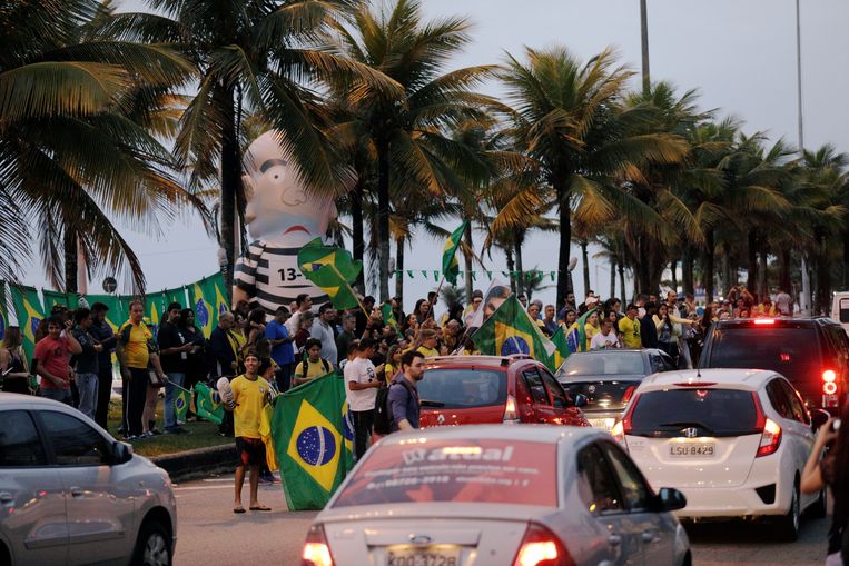 Aanhangers van de extreem-rechtse Jair Bolsonaro verzamelen zich in Rio de Janeiro bij een opblaasbare pop, 'Pixuleco', die oud-president Luiz Inacio Lula da Silva moet voorstellen.  Beeld REUTERS