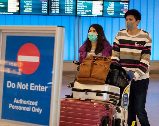 Passagiers uit China dragen een mondmasker bij aankomst op LAX, de grootste luchthaven van Los Angeles.