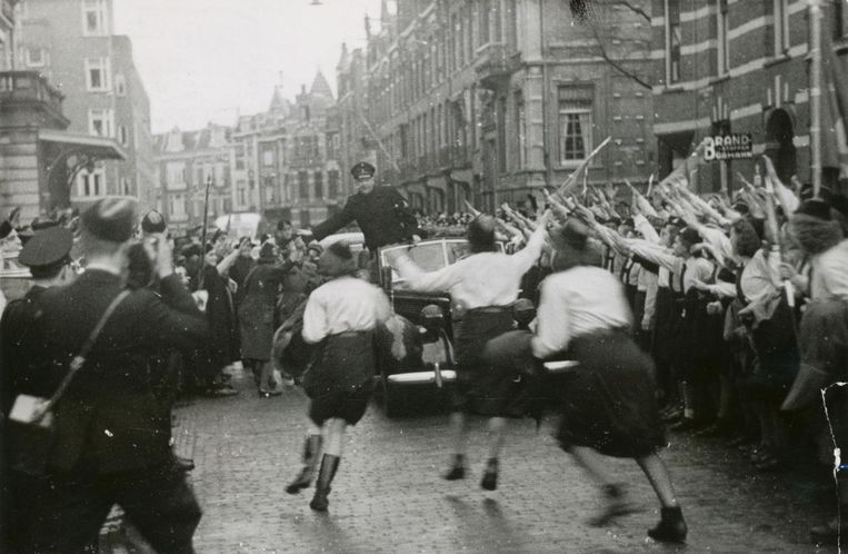 Mussert wordt in de Jan Willem Brouwerstraat uitbundig onthaald door meisjes van de Jeugdstorm na door Hitler te zijn erkent als 'Leider van het Nederlandse volk', 13 december 1942. Beeld Foto: NIOD / N.V. Polygoon, M.E.F. Sagers