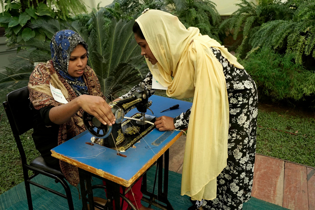 Twee vrouwen die de ramp in het Raza Plazagebouw in Dhaka overleefden, volgen een ngo-cursus naaien. Beeld EPA