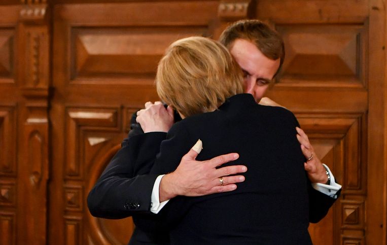 De Franse president Emmanuel Macron omhelst Duits bondskanselier Angela Merkel. Beeld REUTERS