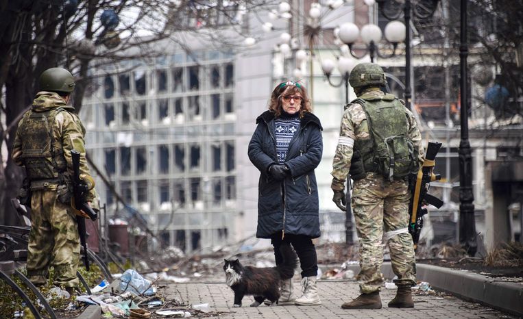 Een vrouw praat in Marioepol met Russische soldaten op 12 april. Dit beeld is gemaakt tijdens een bezoek georganiseerd door het Russische leger. Beeld AFP