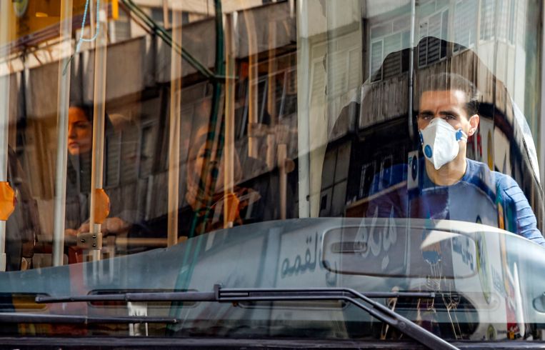 Een buschauffeur met een mondkapje ter bescherming tegen COVID-19 in Teheran, Iran.  Beeld AFP