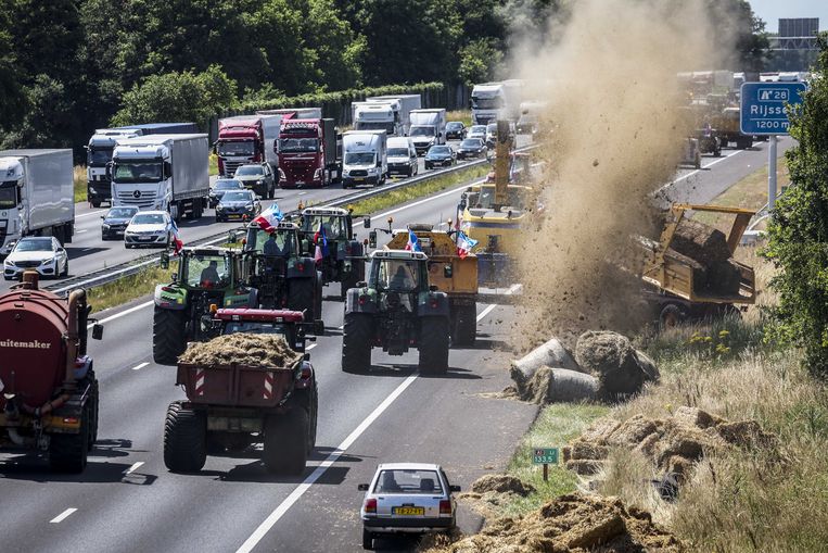 Boeren dumpen onder meer hooibalen en tractorbanden in de berm tijdens een protest op de A1.  Beeld ANP