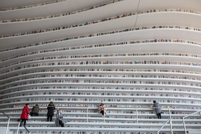 epa06359630 People visit Tianjin Binhai Library, in Tianjin, China, 30 November 2017. The five-story Tianjin Binhai Library, which is also called 'The Eye' occupies an area of 33,700 square meters with floor-to-ceiling bookshelves which can contain up to 1.2 million books. It was designed by Dutch firm MVRDV together with Tianjin's Urban Planning Design Institute and opened in October 2017.  EPA/ROMAN PILIPEY