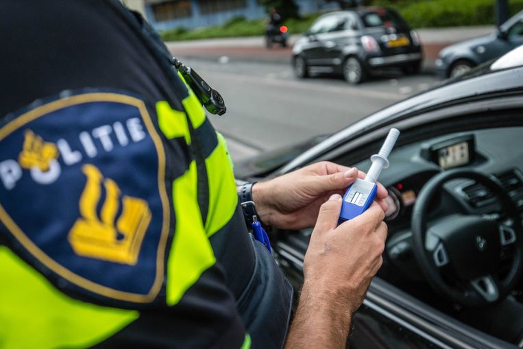 Een agent neemt tijdens een verkeerscontrole een speekseltest af, om te controleren op drugsgebruik. Beeld ANP