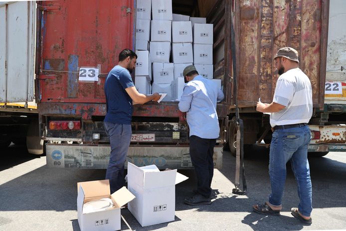 Douaneagenten inspecteren een konvooi met humanitaire hulp aan de Turks-Syrische grens.