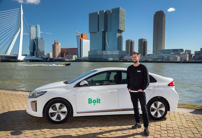 Lars Speekenbrink, country manager Nederland bij Bolt, bij een herkenbare Bolt-taxi. Chauffeurs die voor het logo kiezen, krijgen daarvoor betaald.