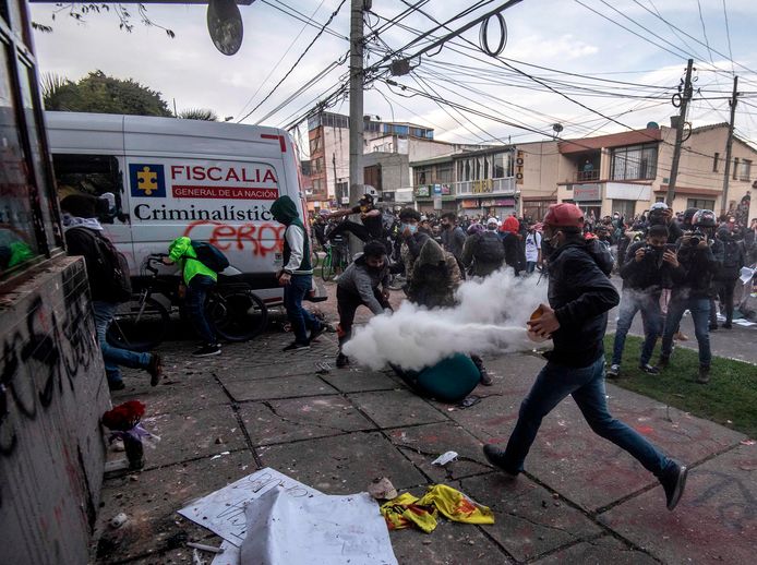 Een demonstrant spuit een brandblusapparaat leeg in Bogota tijdens het protest tegen politiegeweld.
