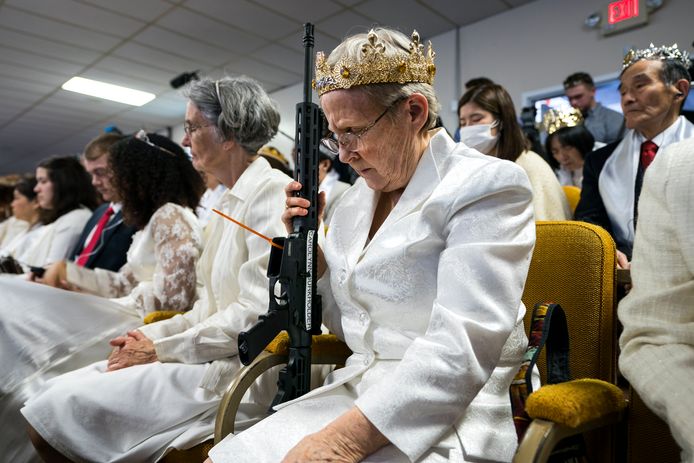 Een gelovige van de Amerikaanse Sanctuary Church in Newfoundland Pennsylvania heeft een semiautomatisch geweer bij zich tijdens een ceremonie om het huwelijk opnieuw in te zegenen. De voorganger van deze gemeente ziet de vuurwapens als symbool voor de “IJzeren Staf” uit het Bijbelboek Openbaringen  2.27. Foto: Jim Lo Scalzo