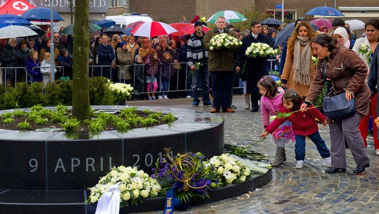 Belangstellenden leggen bloemen bij het nieuwe monument tijdens de herdenking van de schietpartij in winkelcentrum de Ridderhof in Alphen aan den Rijn. Beeld ANP