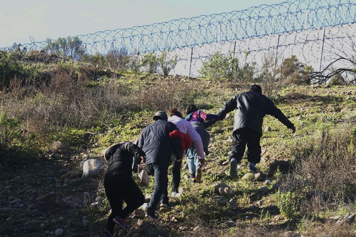 Hondurese migranten proberen in Tijuana de grens met de VS over te steken.