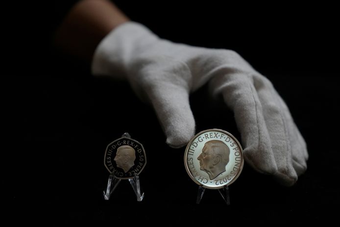 De twee nieuwe munten met het officiële portret van koning Charles III, links de munt van 50 pence, rechts dat van 5 pond.