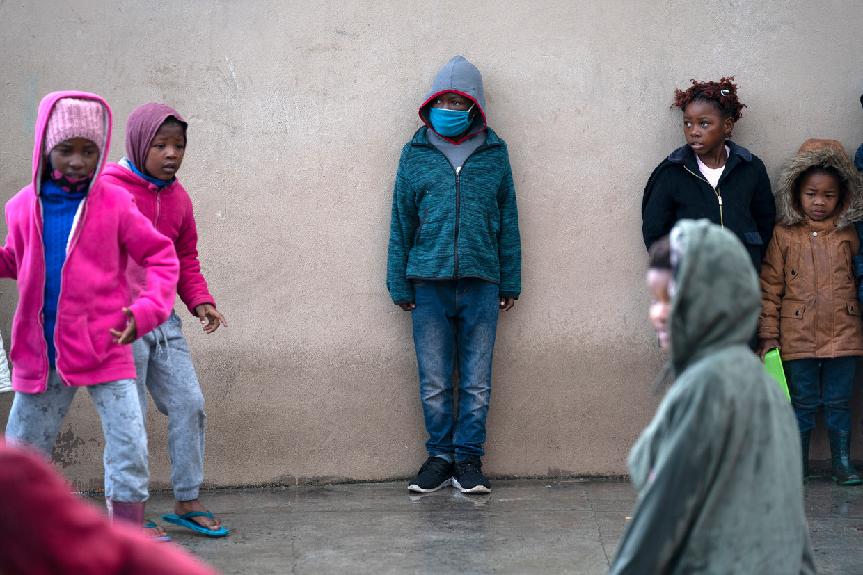 Kinderen schuilen voor de regen in Zuid-Afrika. Beeld EPA