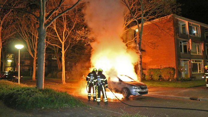 De brandweer doet z'n best, maar de auto valt niet meer te redden.