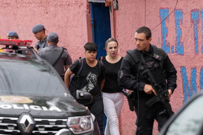 Een jongen wordt opgehaald door zijn moeder nadat een leerling een 71-jarige leerkracht doodstak met een mes en drie andere leraren en twee medeleerlingen verwondde op de Thomazia Montoro-school in Sao Paolo.