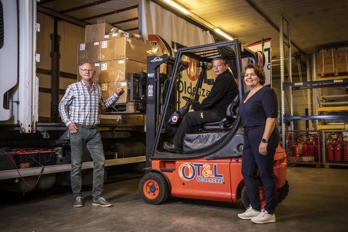 In de praktijkhal zien bestuursvoorzitter Jan Bergman van het Coöperatieve Opleidingscentrum Transport & Logistiek Oldenzaal en Lisette Boetzkes van het OT&L hoe Wout Peters uit Lattrop geroutineerd een pallet vol dozen in de vrachtwagen laadt.