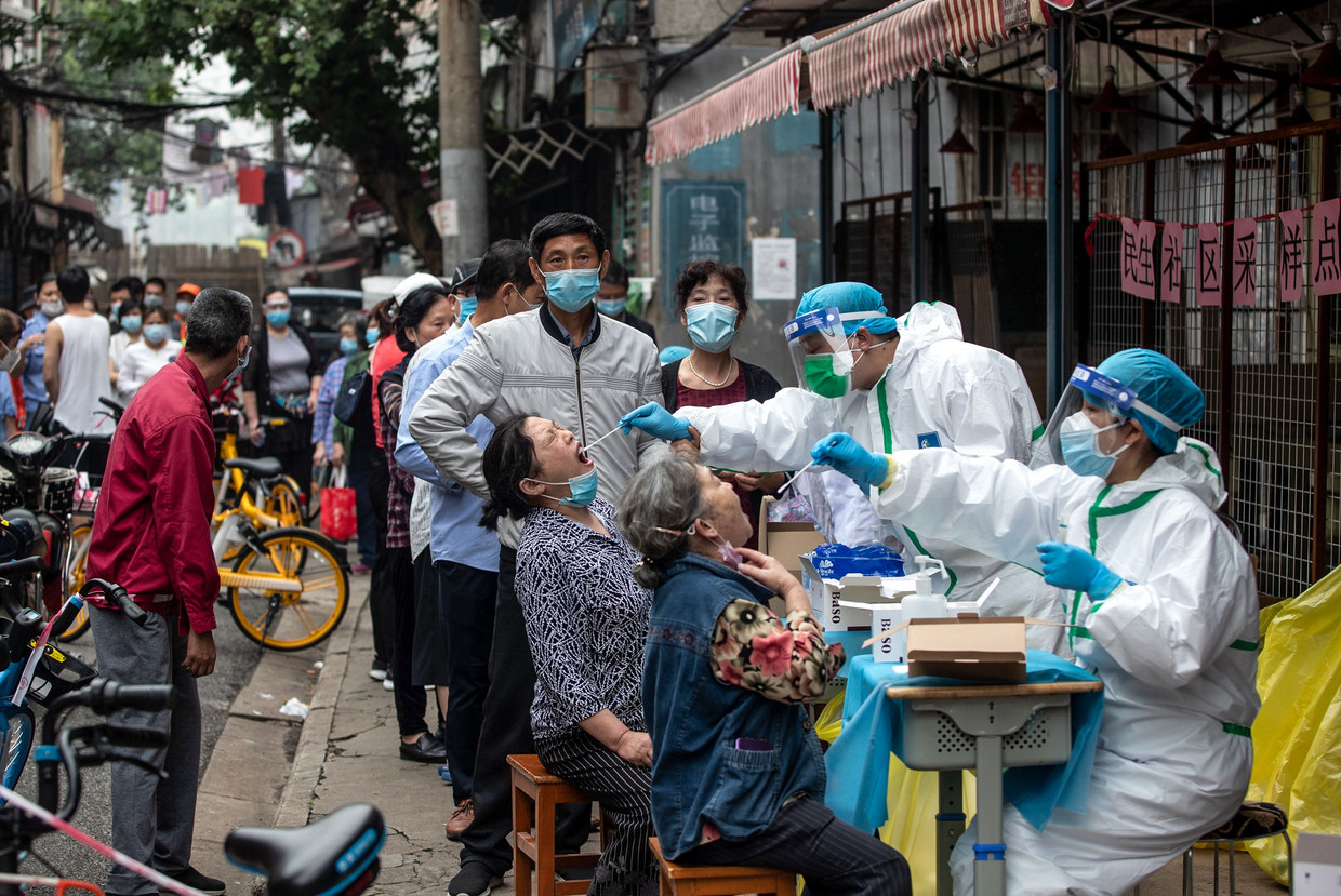 Inwoners van de Chinese stad Wuhan worden gecontroleerd op het coronavirus. Beeld AFP