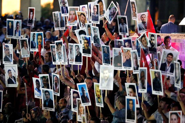 Voor het parlementsgebouw in Ankara tonen betogers foto’s van de 250 slachtoffers van de coup. Het afgelopen jaar verloren ook meer dan 150.000 mensen hun baan. Beeld EPA