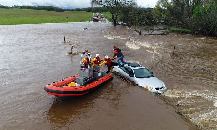 Reddingswerkers uit het Amerikaanse Folsom halen een automobilist uit zijn benarde positie nadat hij werd verrast door het snel stijgende water in een rivier. Foto: Kelly B. Huston