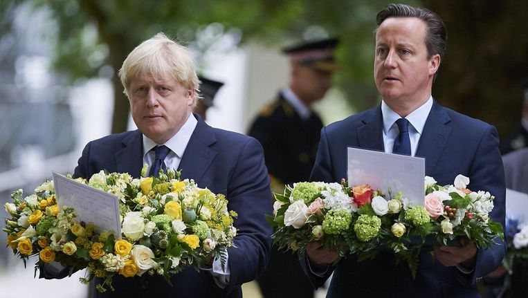 De burgemeester van Londen Boris Johnson (links) en de Britse premier David Cameron leggen kransen in Hyde Park in Londen. Beeld afp