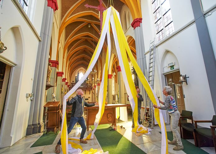 Mari van Asseldonk, Bert van de Tillaart en Beppie Nikkelen (vlnr) zijn al druk bezig met het versieren van de kerk voor het jubileumviering van zondag.