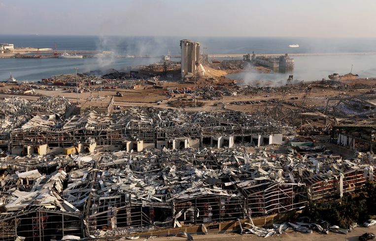 De haven van Beiroet op 4 augustus 2020. Boven de puinhopen uit torenen de resten van de silo's, waarin het ammoniumnitraat zat dat explodeerde.  Beeld Reuters